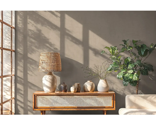 Dekoratives Wohnzimmer mit Lampe, Pflanzen und Kommode
