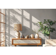 Helle, freundliche Einrichtung mit Holzkonsole, Lampe, Vasen und Zimmerpflanze.