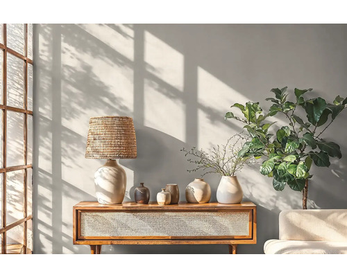 Helles Wohnzimmer mit Konsole, Lampe, Vasen und Zimmerpflanze