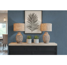 Zwei Tischlampen mit gewebten Lampenschirmen auf einem Sideboard mit Dekoration