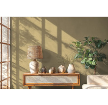 Dekorative Szene mit Tischlampe, Vasen, Tisch und Zimmerpflanze vor einer Wand