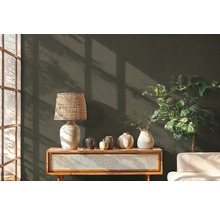 Dekorative Szene mit Lampe, Vasen, Kommode und Zimmerpflanze vor einer Wand