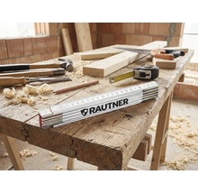 Werkbank mit Hammer, Stechbeitel, Zollstock der Marke Rautner, Bleistift, Holzwolle, Säge und Maßband