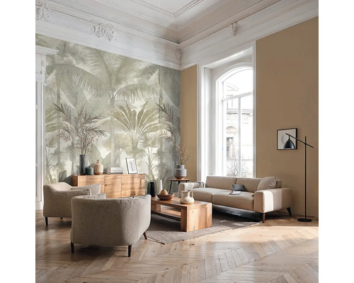 Helles Wohnzimmer mit großflächiger Fototapete mit Palmenmotiv, Sofa, Sesseln, Holzmöbeln und Fischgrätparkett.