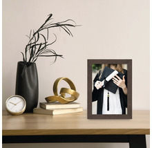 Dekorativer Fotorahmen aus Holz auf einem Tisch mit weiteren Dekorationselementen