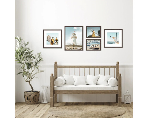 Dekorative Bilderrahmen-Anordnung über einer Holzbank mit Kissen im Wohnzimmer.