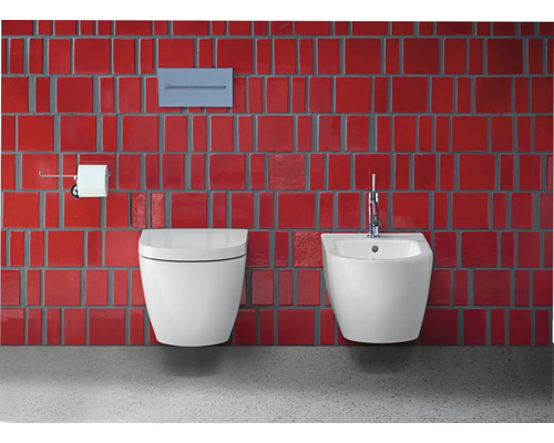 Modernes Badezimmer mit Wand-WC und Bidet vor roter Wandfliese.