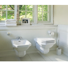 Badezimmer mit Bidet, Toilette und Badaccessoires vor einem Fenster