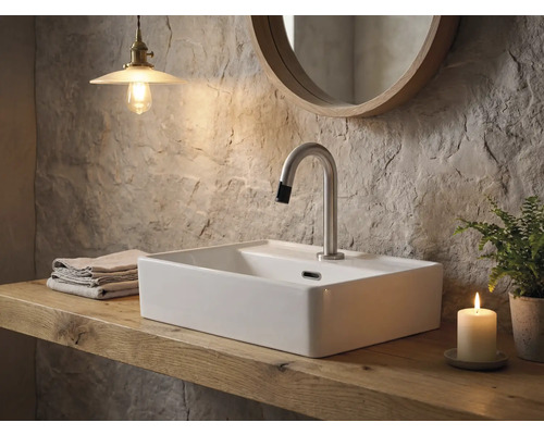 Badezimmer mit Aufsatzwaschbecken, Armatur, Spiegel, Handtüchern, Lampe, Kerze und Topfpflanze auf einem Holztisch