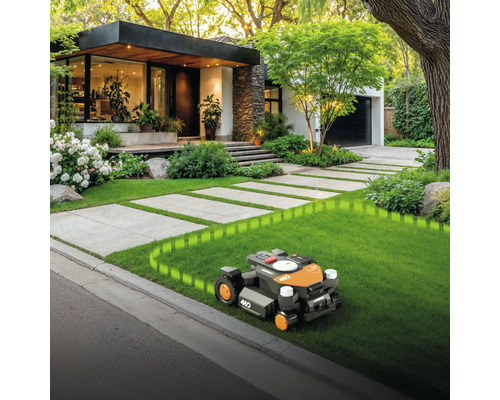 Rasenmähroboter auf Rasen vor Haus mit gepflastertem Weg