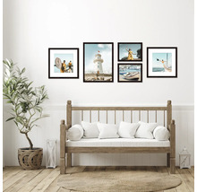 Wohnzimmer mit Holzbank, Zimmerpflanze und Bilderrahmen mit maritimen Motiven an der Wand