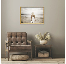 Dekoratives Wohnzimmer mit Sessel, Beistelltisch und gerahmtem Strandbild an der Wand