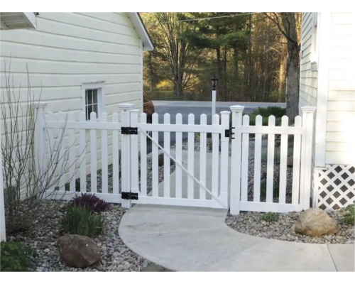 Gartenszene mit weißem Lattenzaun und Gartentür