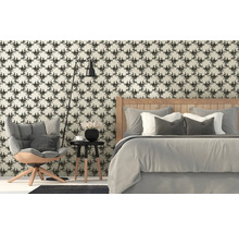 Schlafzimmer mit floral gemusterter Tapete, Bett, Sessel und Stehlampe