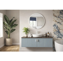 Helles Badezimmer mit Waschtisch, rundem Spiegel und Zimmerpflanzen.