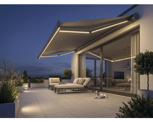 Terrasse mit Markise, Gartenmöbeln und Beleuchtung am Abend