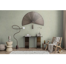 Modern gestaltetes Zimmer mit hellgrüner Wandfarbe, einem großen dekorativen Fächer, einem Konsolentisch und einem geflochtenen Sessel.