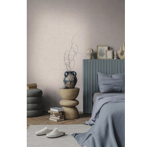Modernes Schlafzimmer mit blauem geripptem Kopfteil, skulpturalem Beistelltisch aus Holz, dekorativer Vase und strukturierten Wänden.