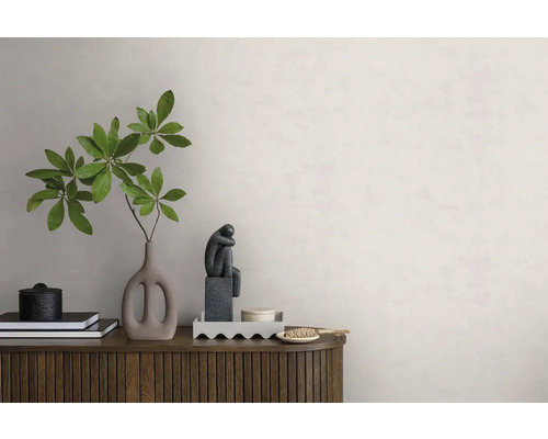 Moderne Wandgestaltung mit heller Wandfarbe, einem Holz-Sideboard, einer Vase mit grünem Zweig und dekorativen Objekten.