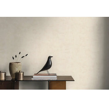 Helle Wand mit strukturierter Tapete in einem minimalistischen Raum mit Sideboard, dekorativer Vogelfigur und einer Stein-Vase.