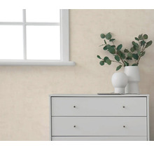 Strukturierte beige Tapete in hellem Raum neben weißem Fenster und weißer Kommode mit Vasen und Eukalyptuszweigen.