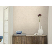 Strukturierte beige Tapete an einer Wand hinter einem hölzernen Sideboard mit Dekoration. Helle, aufgeräumte Raumatmosphäre.