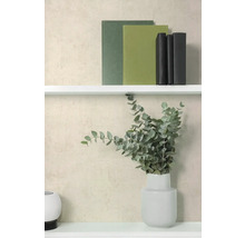 Strukturierte Vliestapete in Beige hinter einem weißen Regal mit Büchern und einer Vase mit Eukalyptuszweigen.