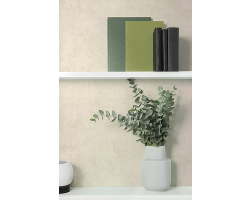 Strukturierte Vliestapete in Beige hinter einem weißen Regal mit Büchern und einer Vase mit Eukalyptuszweigen.