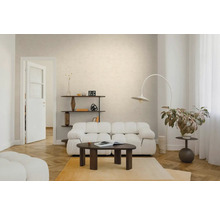 Hell eingerichtetes Wohnzimmer mit weißem Polstersofa, dunklem Couchtisch aus Holz, Bogenlampe und Parkettboden in Fischgrätoptik.