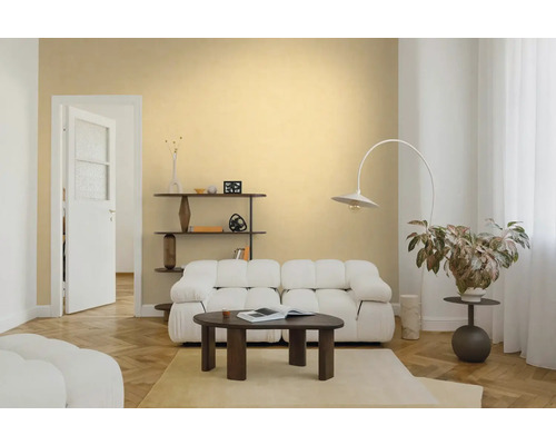 Helles Wohnzimmer mit beiger Wandfarbe, weißem Sofa, dunklem Couchtisch aus Holz, Bogenlampe und Fischgrätparkett.