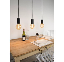 Szene mit drei Pendelleuchten über einem Esstisch mit Geschirr und Getränken