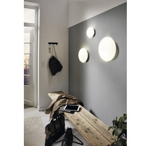 Heller Eingangsbereich mit Holzhocker, Wandleuchten und Garderobe