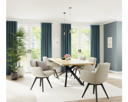 Heller Essbereich mit Holztisch, Stühlen und Zimmerpflanzen vor Fenstern mit Vorhängen