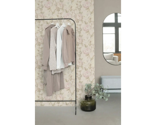 Vliestapete mit romantischem Rosenmuster in Beige und Rosa hinter einem Kleiderständer in einem modern eingerichteten Ankleidezimmer.