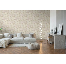 Vliestapete mit hellem Rosenmuster in einem modern eingerichteten Wohnzimmer mit Sofa, Fischgrätparkett und Stehleuchte.
