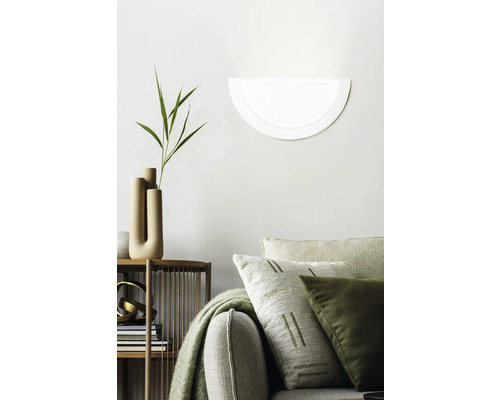 Dekoratives Wohnzimmer mit Wandleuchte, Sofa und Regal