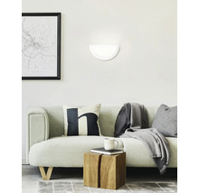 Wohnzimmer mit Sofa, Wandleuchte und Dekorationsgegenständen für ein gemütliches Ambiente