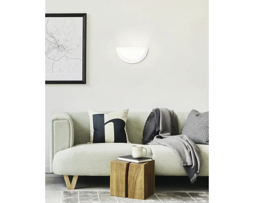 Wohnzimmer mit Sofa, Wandleuchte und Dekorationsgegenständen für ein gemütliches Ambiente