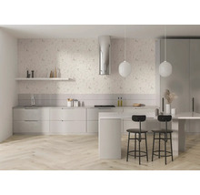 Helle, moderne Küche mit floraler Tapete, hellem Fischgrät-Holzboden, weißen Schränken, Kochinsel, schwarzen Barhockern und runden Pendelleuchten.