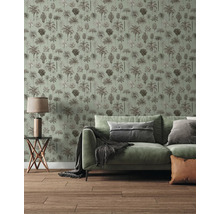 Vliestapete mit Palmen-Muster in einem hellen Wohnzimmer mit grünem Sofa und Holzboden.
