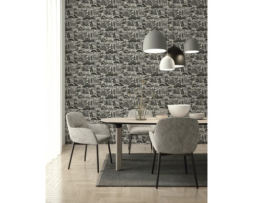 Vliestapete mit Waldmuster in Schwarz-Weiß in einem modern eingerichteten Esszimmer mit Holztisch und grauen Polsterstühlen.