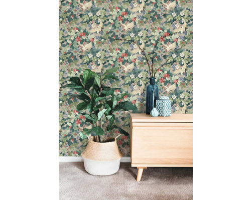 Vliestapete mit Kranich- und Blumenmuster an einer Wand hinter einer Kommode und einer Zimmerpflanze im Korb.