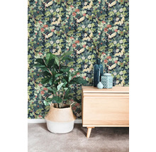 Vliestapete mit Kranich- und Blumenmuster in einem Raum mit Sideboard aus Holz und Zimmerpflanze im geflochtenen Korb.