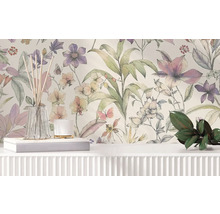 Vliestapete mit floralem Muster aus großen Blumen und Blättern im Aquarellstil hinter einem weißen Sideboard mit Dekoration.