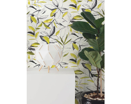 Moderne Vliestapete mit gelbem und schwarzem Blättermuster im Skizzenstil hinter einer weißen Lampe und einer grünen Zimmerpflanze.