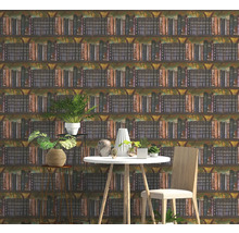 Vliestapete mit Bücherregal-Motiv in einem modern eingerichteten Zimmer mit weißem Tisch, Holzstuhl und Zimmerpflanzen.