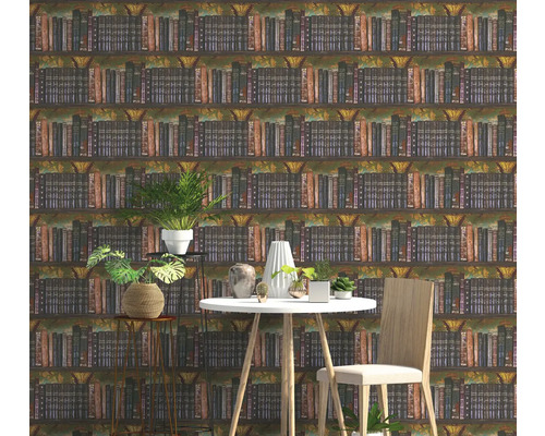 Vliestapete mit Bücherregal-Motiv in einem modern eingerichteten Zimmer mit weißem Tisch, Holzstuhl und Zimmerpflanzen.