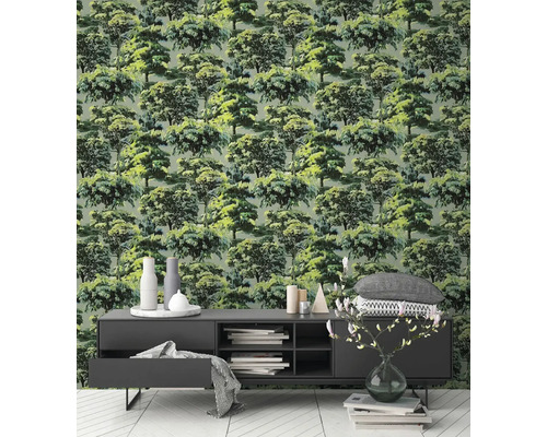 Vliestapete mit detailliertem Waldmotiv und grünen Bäumen in einem modern gestalteten Wohnzimmer mit dunklem Sideboard und hellem Boden.