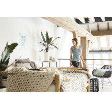 Helles Schlafzimmer mit Doppelbett, Zimmerpflanzen und Holzelementen