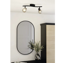 Deckenleuchte mit zwei Spots und ovaler Spiegel über Kommode